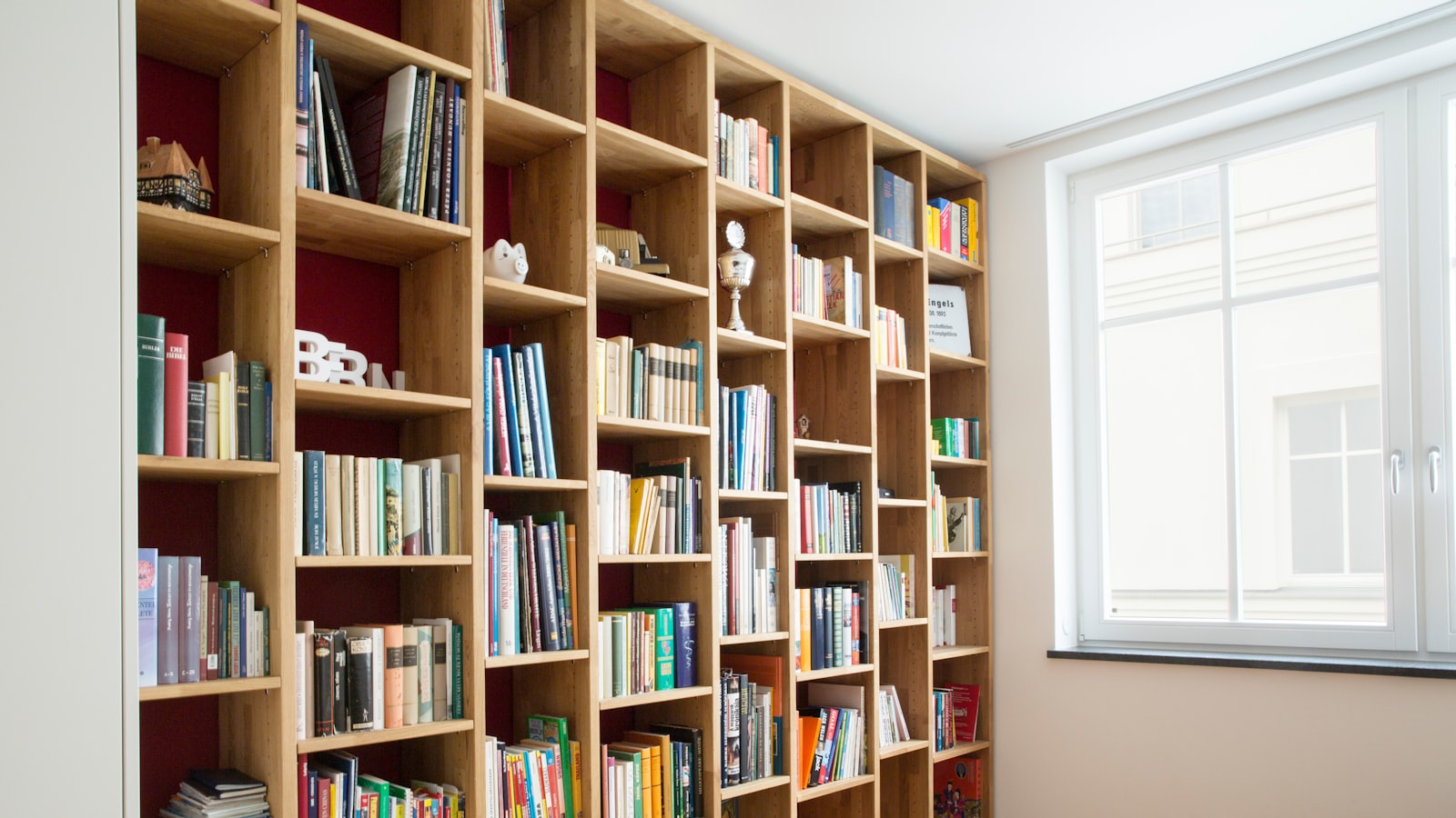 A wooden floating shelf mounted on a plain wall holding a few small objects.